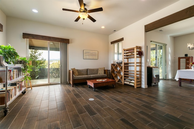 living room with recessed lighting, plenty of natural light, wood tiled floor, and ceiling fan with notable chandelier