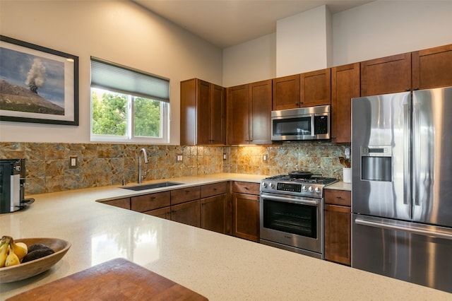 kitchen with backsplash, appliances with stainless steel finishes, and a sink