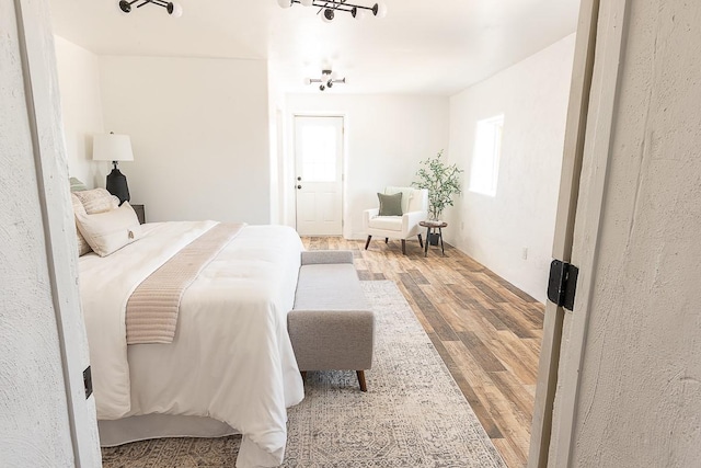 bedroom featuring wood finished floors and a chandelier