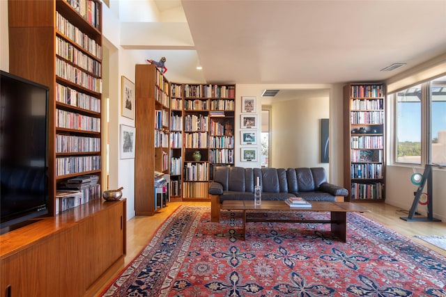 unfurnished living room featuring bookshelves, visible vents, and built in features