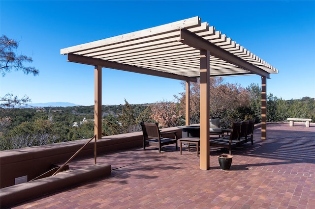 view of patio / terrace featuring visible vents, a view of trees, and a pergola