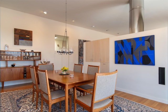 dining space featuring a notable chandelier, baseboards, and wood finished floors