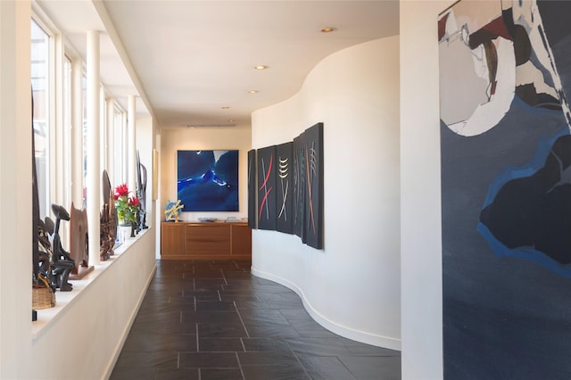 hallway with recessed lighting and baseboards