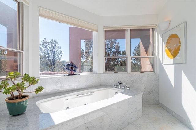 full bath featuring baseboards, marble finish floor, and a whirlpool tub