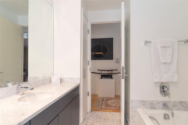 bathroom featuring a bathtub, marble finish floor, and vanity