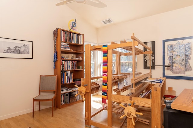 office space featuring visible vents, baseboards, vaulted ceiling, wood finished floors, and a ceiling fan