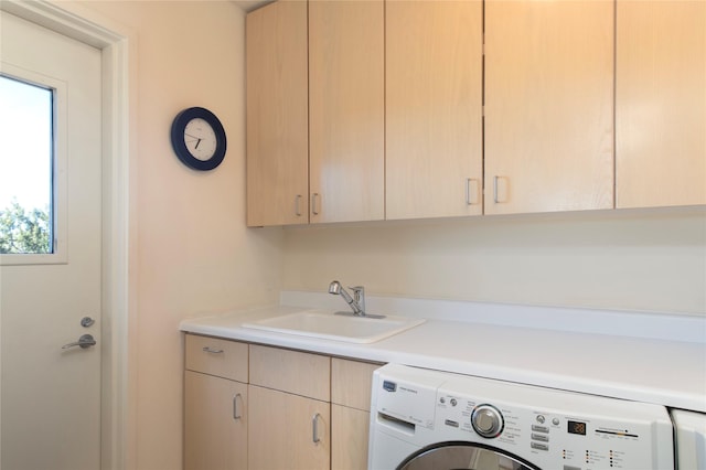 clothes washing area featuring a sink, washer / clothes dryer, and cabinet space