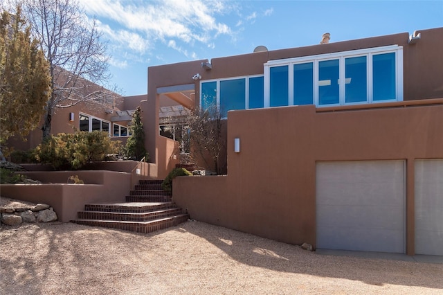 view of side of property with stucco siding and an attached garage