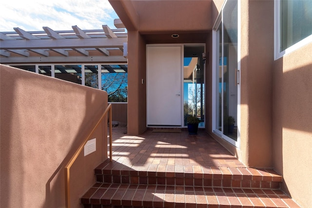 view of exterior entry featuring stucco siding