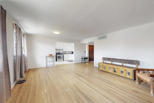 unfurnished living room featuring visible vents and light wood-style flooring