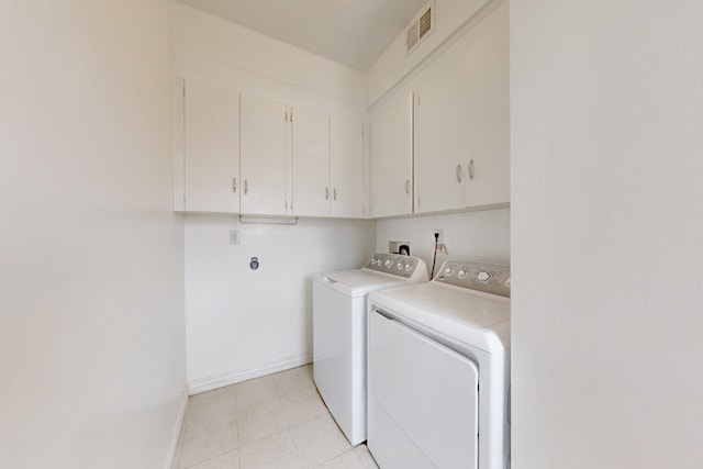 clothes washing area featuring visible vents, baseboards, light tile patterned floors, cabinet space, and separate washer and dryer