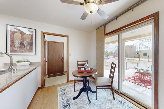 dining area with light wood-type flooring and ceiling fan