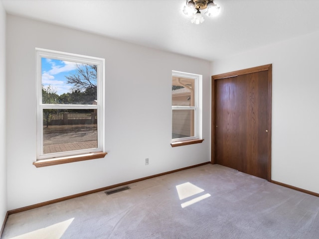 unfurnished bedroom with a closet, baseboards, carpet, and visible vents