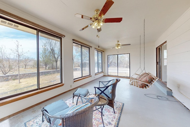 sunroom featuring concrete flooring and baseboards