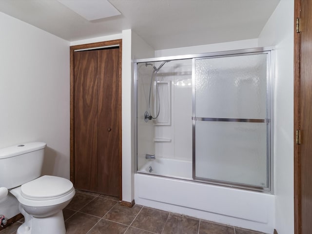 bathroom featuring bath / shower combo with glass door, toilet, and tile patterned flooring