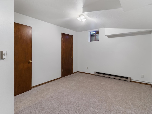 empty room with carpet flooring, a baseboard heating unit, and baseboards