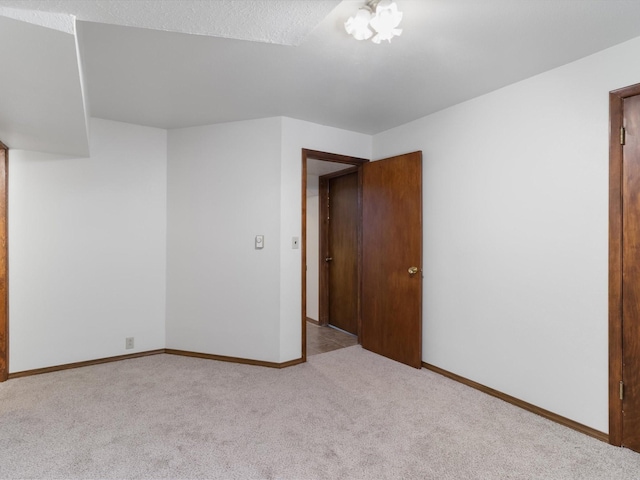 carpeted empty room with baseboards