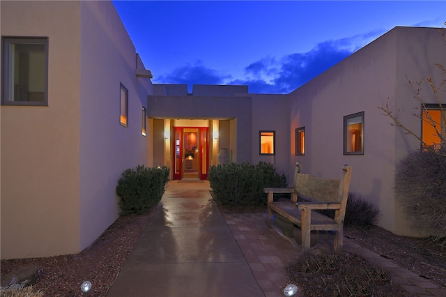 570 Via Arista, Santa Fe, NM 87506 - exterior entry at dusk featuring stucco siding