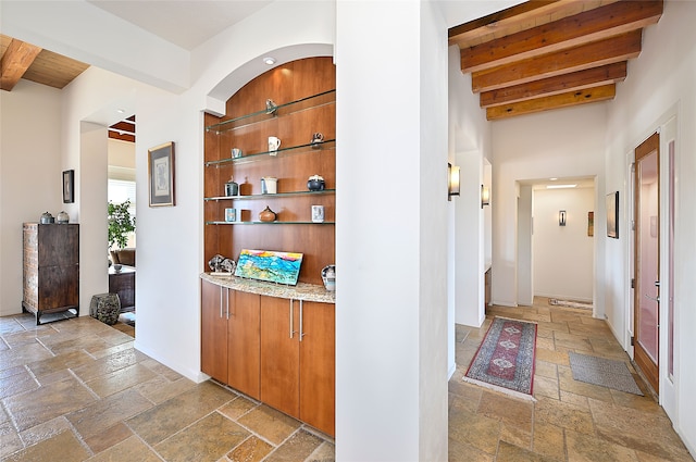 570 Via Arista, Santa Fe, NM 87506 - hallway with stone tile floors, beam ceiling, and baseboards