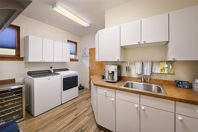 570 Via Arista, Santa Fe, NM 87506 - laundry area with wine cooler, light wood-style flooring, independent washer and dryer, a textured ceiling, and a sink