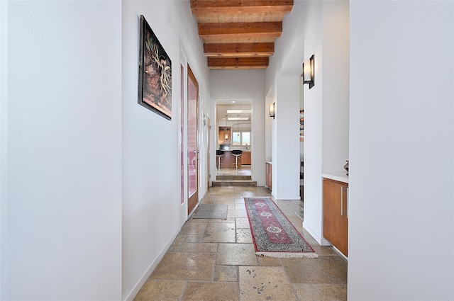 570 Via Arista, Santa Fe, NM 87506 - hall featuring baseboards, beam ceiling, and stone tile flooring