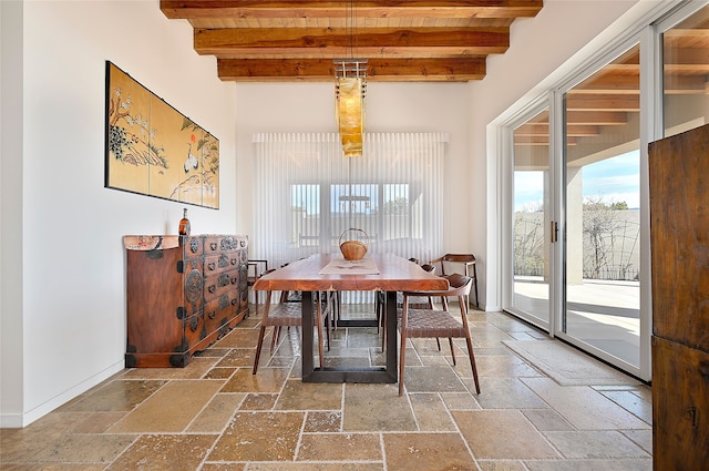 570 Via Arista, Santa Fe, NM 87506 - dining room featuring stone tile floors, beam ceiling, wood ceiling, and baseboards