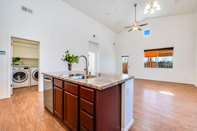 kitchen with stainless steel dishwasher, visible vents, washing machine and dryer, open floor plan, and a sink