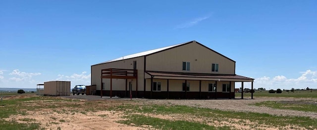 back of property with an outdoor structure and metal roof