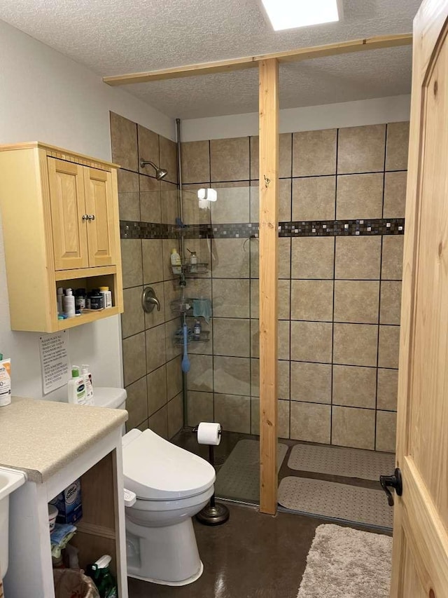 bathroom with a shower stall, a textured ceiling, and toilet