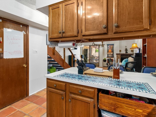 kitchen featuring light countertops, light tile patterned flooring, and brown cabinetry