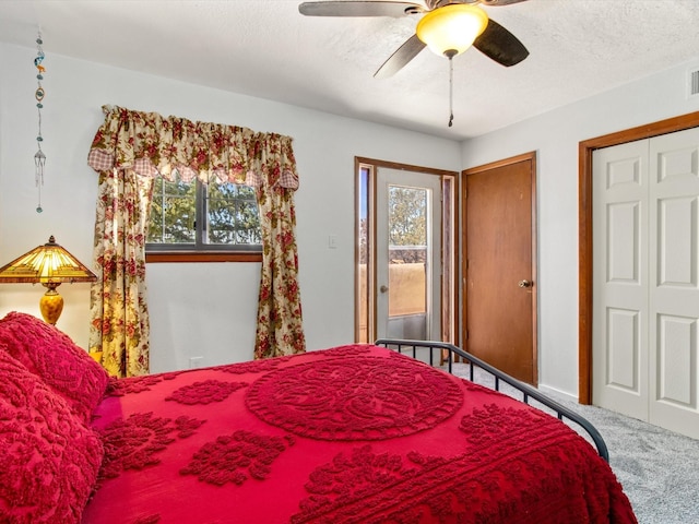 carpeted bedroom with multiple windows, a ceiling fan, visible vents, and a textured ceiling