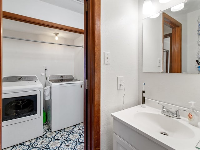 washroom featuring a sink, separate washer and dryer, and laundry area