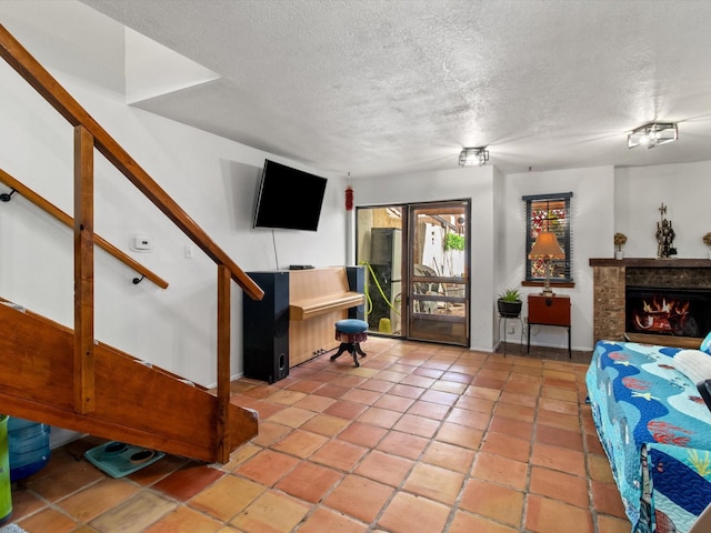 interior space featuring light tile patterned floors, a textured ceiling, and stairs