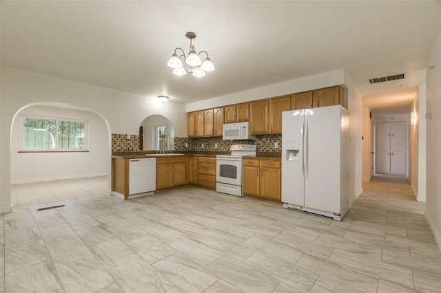 kitchen featuring white appliances, decorative backsplash, a chandelier, dark countertops, and visible vents