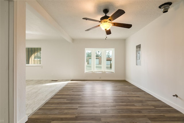 unfurnished room with a ceiling fan, dark wood finished floors, and baseboards