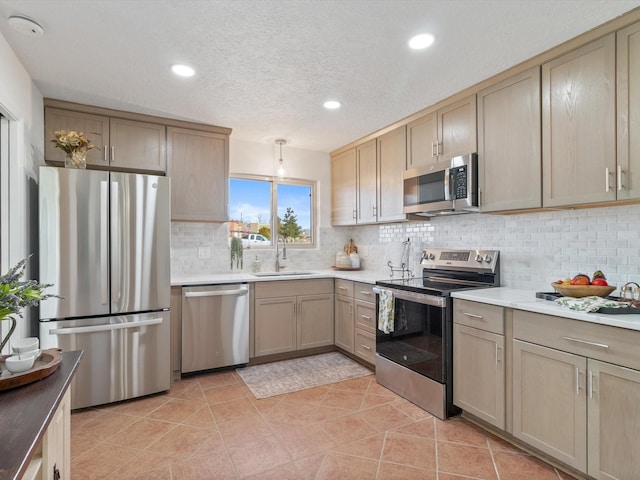 2606 Alamosa Dr, Santa Fe, NM 87505 - kitchen with light tile patterned flooring, light countertops, backsplash, a sink, and stainless steel appliances