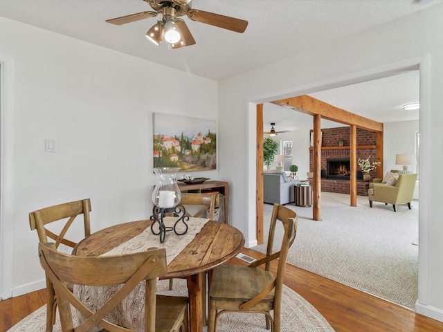 2606 Alamosa Dr, Santa Fe, NM 87505 - dining room with visible vents, baseboards, a fireplace, wood finished floors, and a ceiling fan