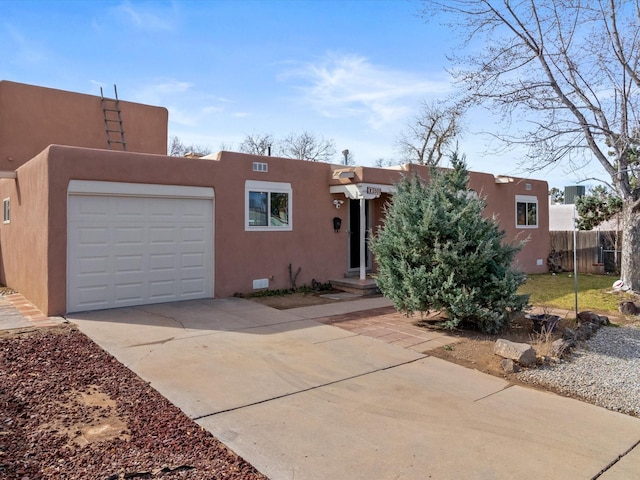 2606 Alamosa Dr, Santa Fe, NM 87505 - southwest-style home with stucco siding, an attached garage, fence, and concrete driveway