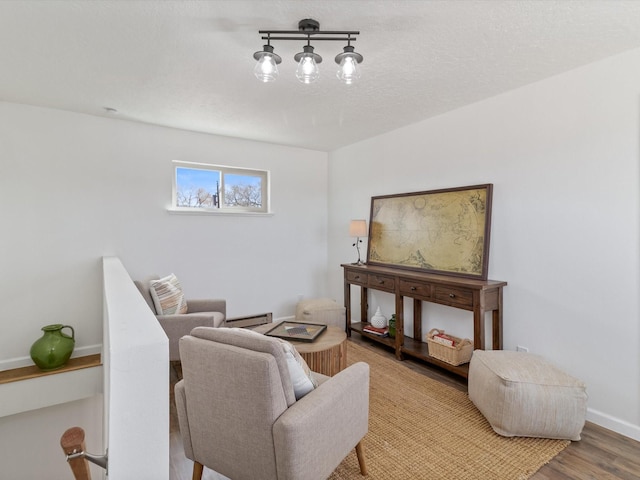 2606 Alamosa Dr, Santa Fe, NM 87505 - living room with baseboards, a textured ceiling, wood finished floors, and baseboard heating