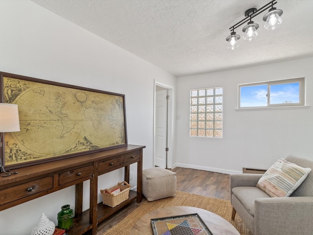 2606 Alamosa Dr, Santa Fe, NM 87505 - living room featuring a textured ceiling, baseboards, a baseboard heating unit, and wood finished floors