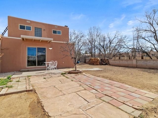 2606 Alamosa Dr, Santa Fe, NM 87505 - rear view of house featuring fence, stucco siding, and a patio area