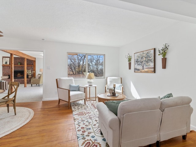 2606 Alamosa Dr, Santa Fe, NM 87505 - living area featuring light wood finished floors, baseboards, a fireplace, and a textured ceiling