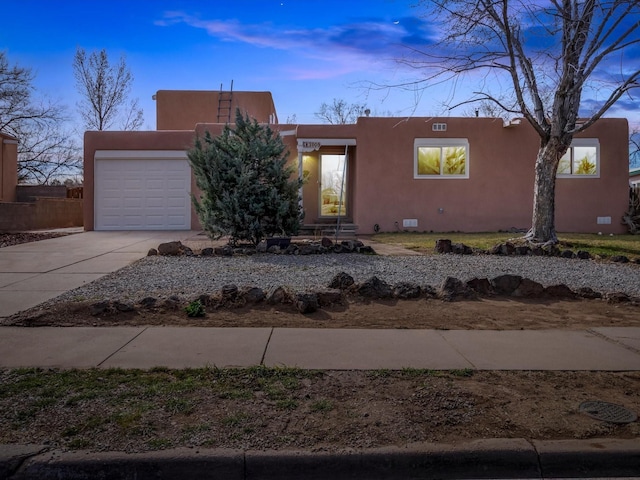 2606 Alamosa Dr, Santa Fe, NM 87505 - pueblo-style house featuring stucco siding, concrete driveway, crawl space, and a garage