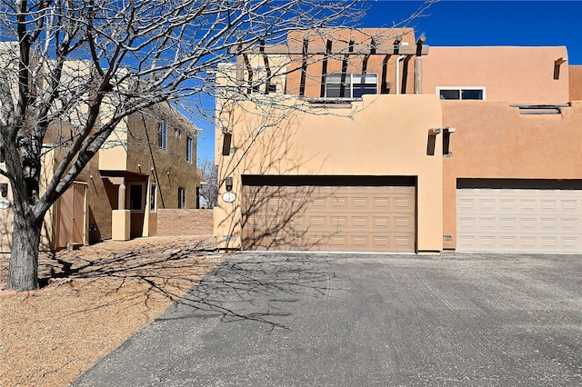 9 E Saddleback Mesa, Santa Fe, NM 87508 - southwest-style home featuring stucco siding, an attached garage, and driveway