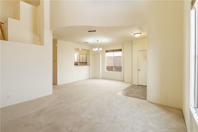 9 E Saddleback Mesa, Santa Fe, NM 87508 - unfurnished living room with a chandelier and carpet floors