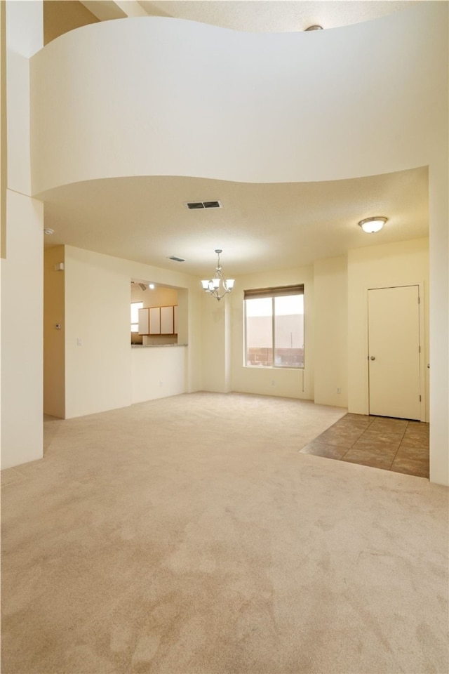 9 E Saddleback Mesa, Santa Fe, NM 87508 - unfurnished living room with carpet floors and a chandelier