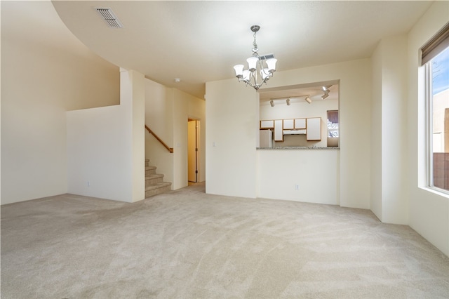 9 E Saddleback Mesa, Santa Fe, NM 87508 - unfurnished room featuring a chandelier, light colored carpet, and stairway