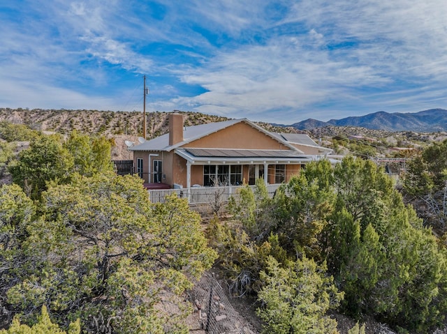 75A Camino Chupadero, Santa Fe, NM 87506 - back of house with a chimney, a mountain view, and metal roof