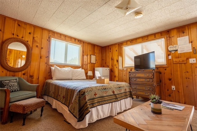 carpeted bedroom featuring wooden walls