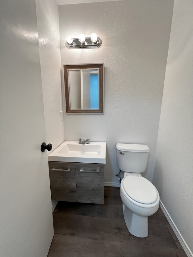 1666 Calle De Oriente Norte, Santa Fe, NM 87507 - half bathroom with toilet, vanity, baseboards, and wood finished floors